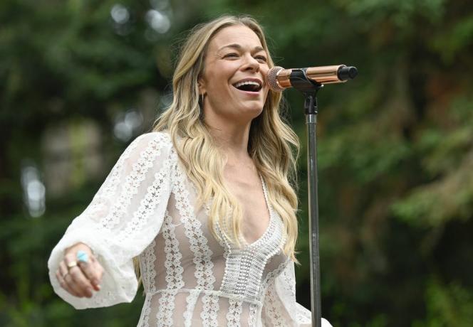 leann rimes pjeva na pozornici s mikrofonom u bijeloj čipkastoj haljini