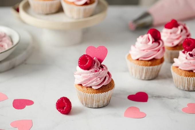 svježe napravljeni kolačići od malina na kuhinjskom pultu ukusni ružičasti kolačići s preljevom od malina i papirnatih srca
