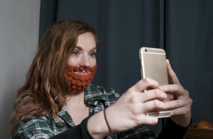 žena s crvenom heklanom bradom snima selfie za dan svetog patrika