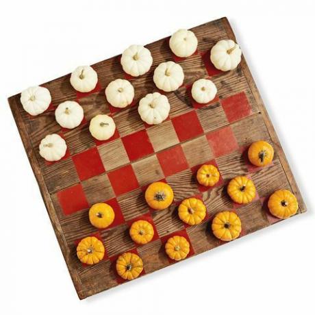 drvena ploča oslikana poput igre za dame pomoću mini bundeva u bijeloj i narančastoj boji