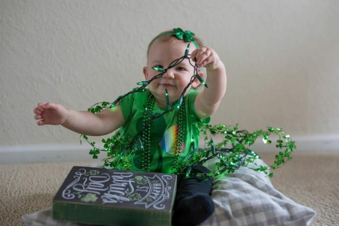 beba djevojčica u zelenom i igra se s ukrasima za dan svetog Patrika možete napisati naslov male miss shamrock na instagramu