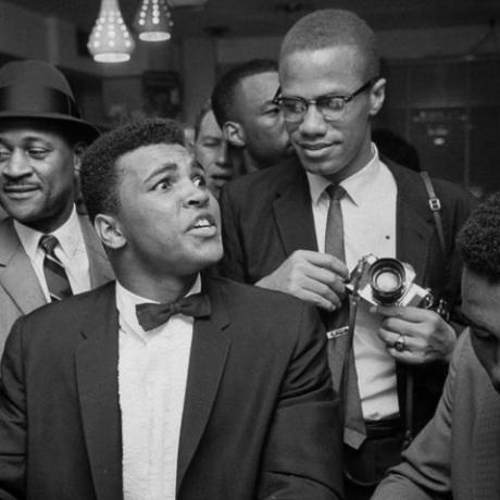 ožujak u Miamiju 1964. crni muslimanski vođa malcolm x 2r, zadirkujući naslonjen na rame od Cassius gline presvučene smokvom, sada Muhammad Ali l, koji samozadovoljno sjedi za šankom soda fontane, okružen veselim navijačima nakon što je pobijedio Sonnyja Listona za svjetsko prvenstvo u teškoj kategoriji photo by bob gomelthe life images collection via getty imagesgetty images