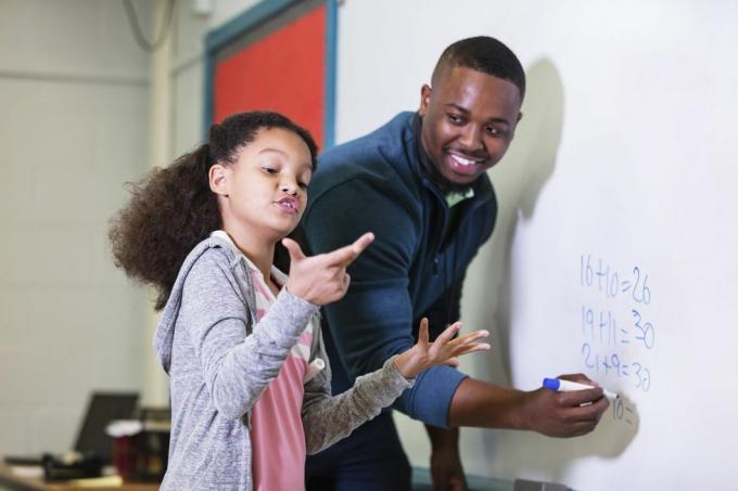 9-godišnja djevojčica više rase na satu matematike, stoji za pločom sa svojim učiteljem, mladim Afroamerikancem u svojoj 20-ih Učitelj gleda svoju osnovnoškolku, čeka dok ona pokušava smisliti odgovor, fokus je na djevojka