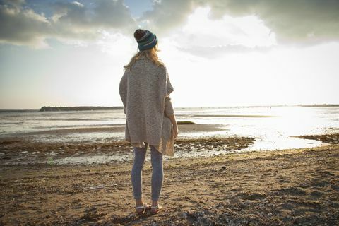 Mlada žena koja gleda na plažu Bournemouth, Dorset, Velika Britanija