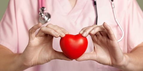 kardiolog u ružičastim pilingima koji drže crveno srce