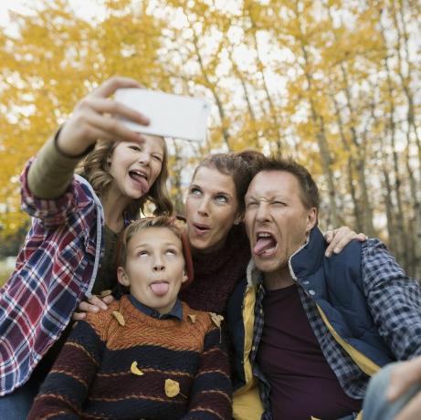 Glupa obitelj koja snima selfieje pravi lica jesenski park