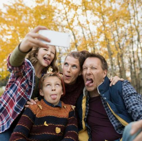 Glupa obitelj koja snima selfieje pravi lica jesenski park