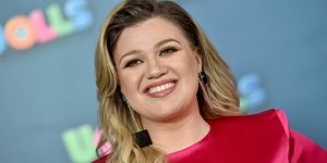 kelly clarkson se smiješi u ružičastoj haljini i četvrtastim crnim naušnicama